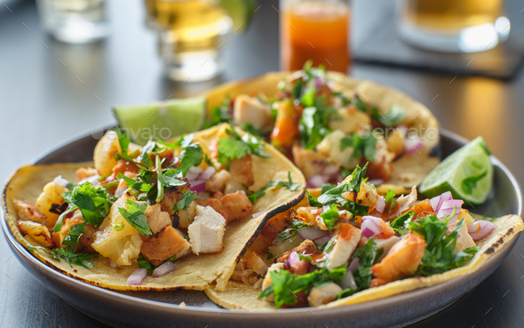 colorful grilled pineapple and chicken street tacos on plate with lime