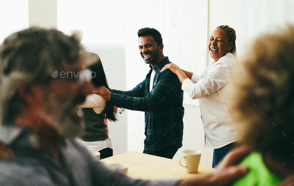 Multiracial happy friends having fun dancing together in the kitchen - Soft focus on Indian man face