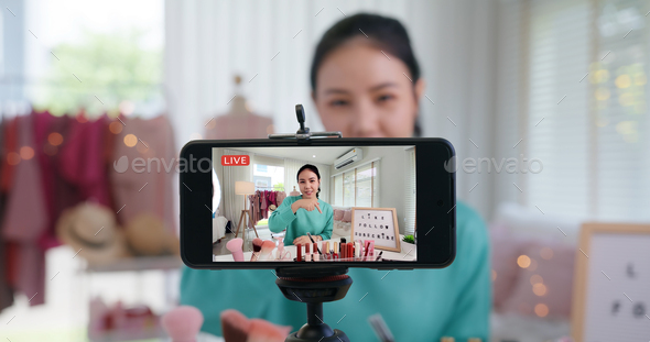 Asia woman micro influencer record live viral video camera at home studio.