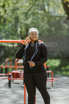 Afro-american plus size woman doing workout exercises session outdoor