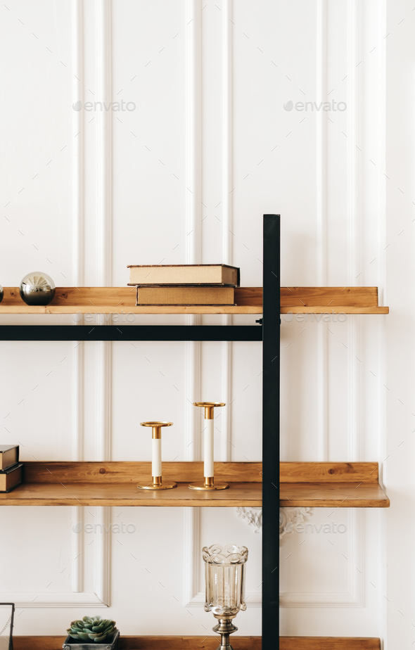 Decorative wooden shelves in living room with books and candlesticks