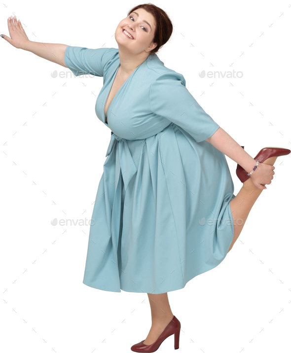 a woman in a blue dress with her leg up in the air