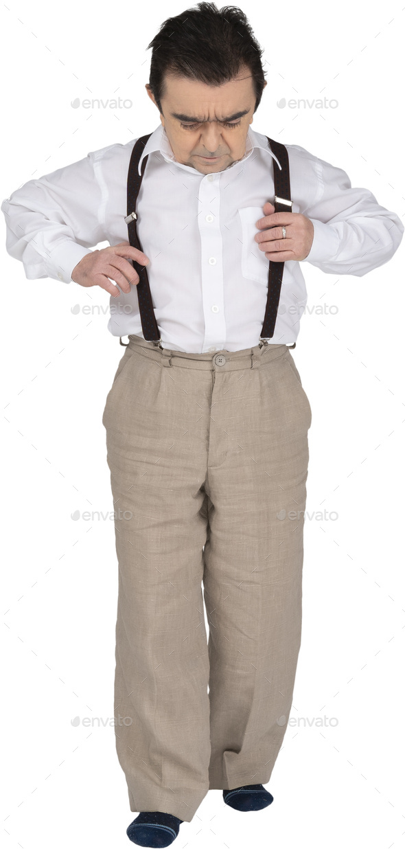 Bearded Old Man In A White Shirt, Brown Trousers With Suspenders And Black  Loafers. He Threw Up His Hands And Ran Up To You, Wants To Hug, Blue Studio  Background. Fashion And