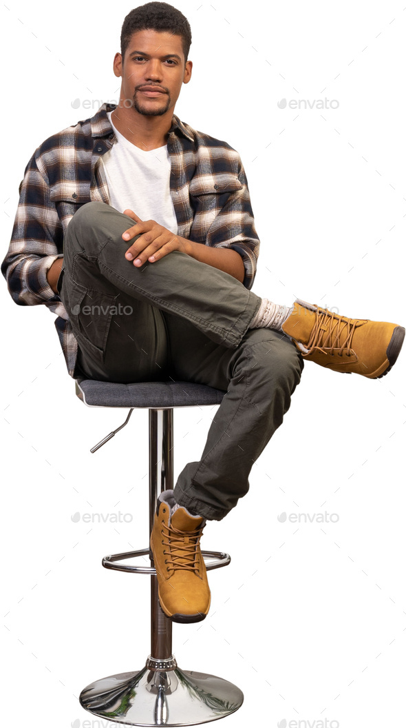 a man sitting on a stool with his feet up on a chair