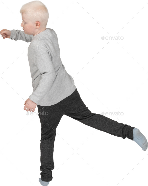 a young boy running with his leg up in the air