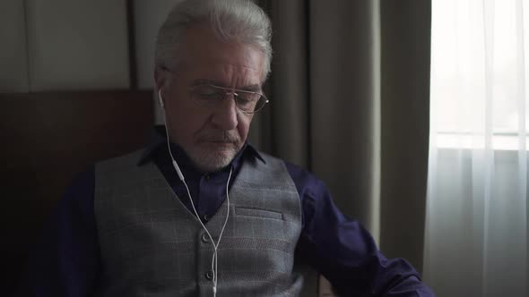 Portrait of an Grayhaired Designer with Glasses Working on a Project and Writing Down Thoughts in a alt