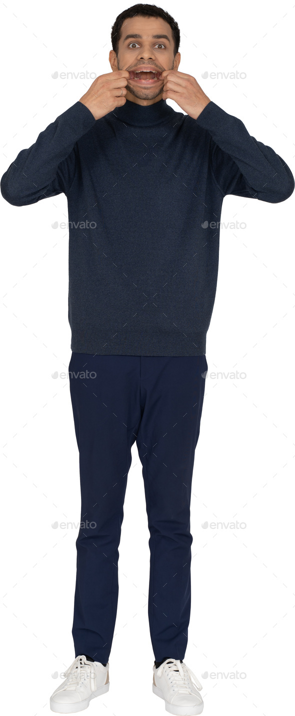 a man wearing a navy sweatshirt and blue pants with his hands on his face