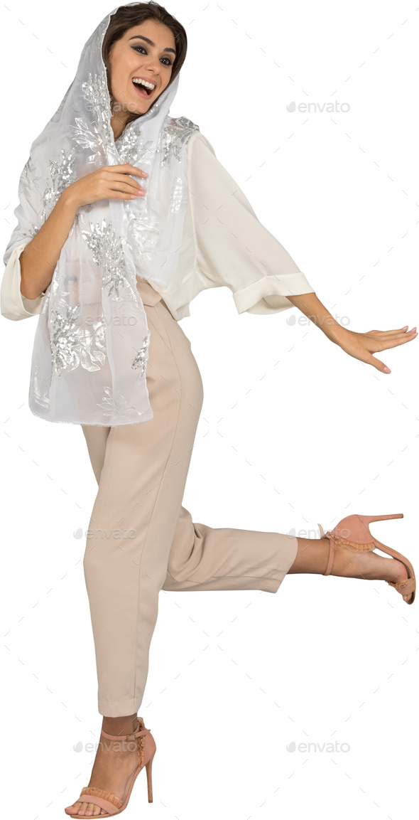 a woman in a white shirt and pants with her leg up in the air