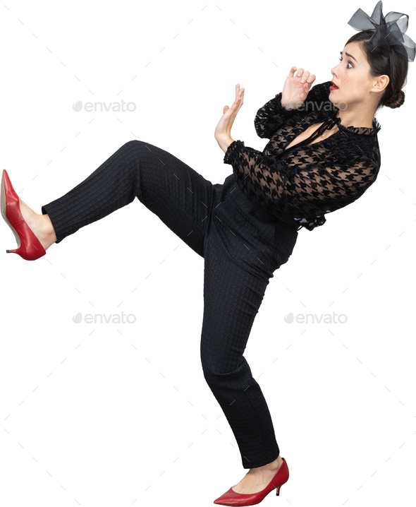 a woman in red heels and black pants kicking her leg up in the air