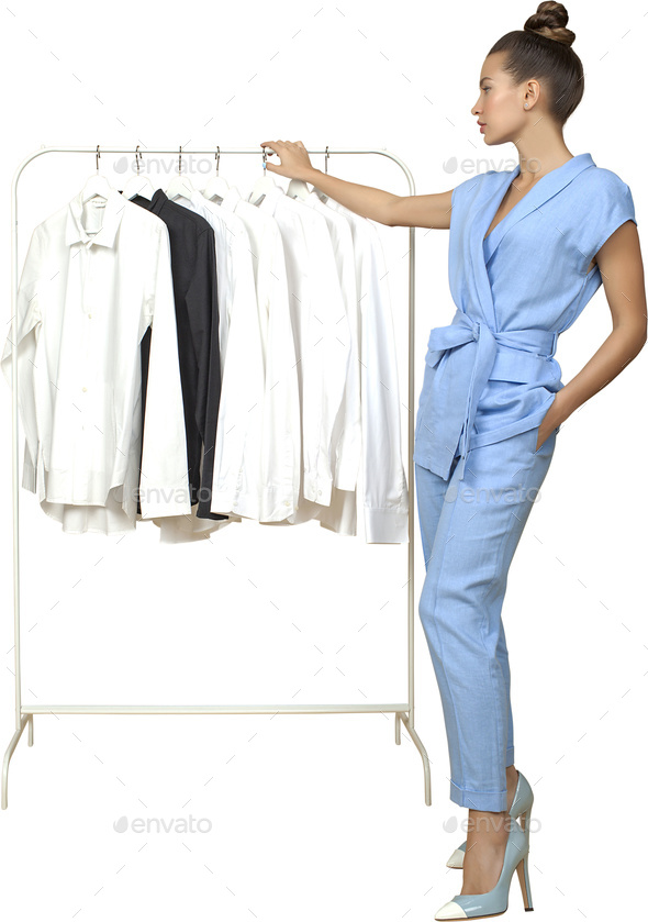 a woman in a blue jumpsuit is standing next to a rack of clothes