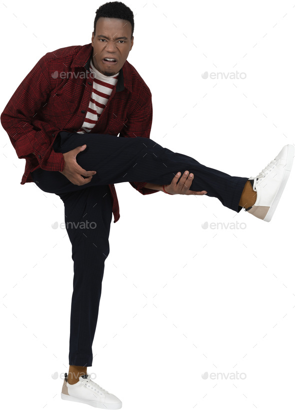 a man in a red shirt and black pants kicking his leg up in the air
