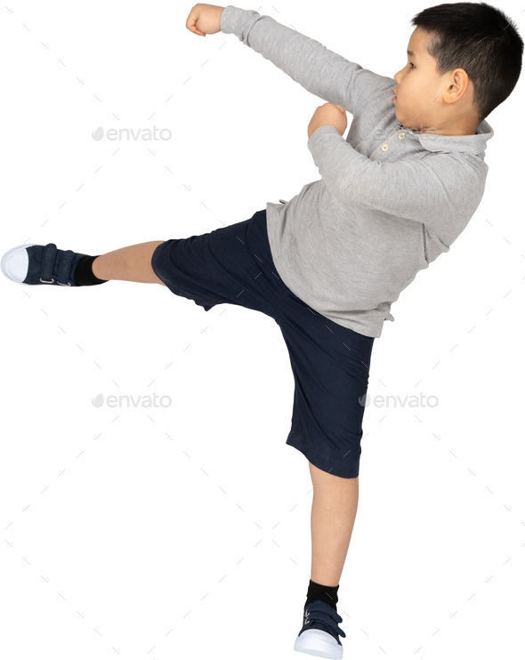 a young boy kicking his leg up in the air