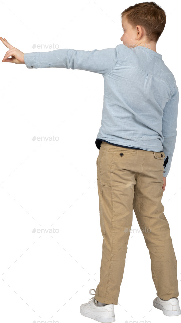 a young boy is standing with his arm outstretched and pointing Stock ...