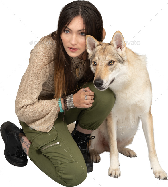 a woman kneeling down next to a dog