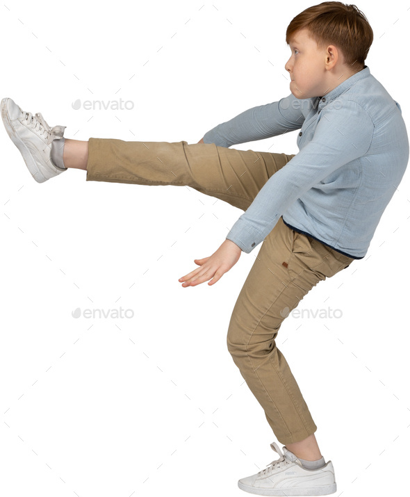 a young boy is kicking his leg up in the air