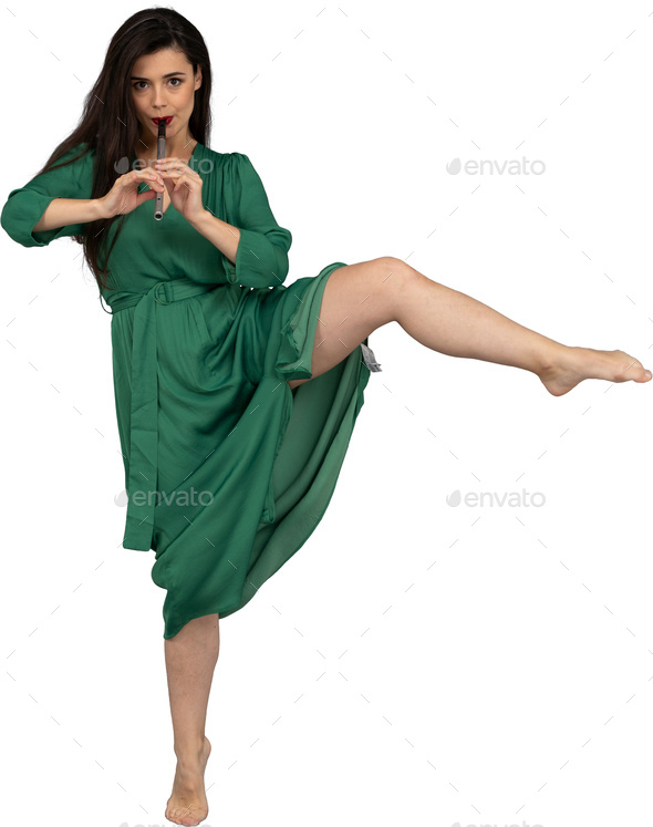 a woman in a green dress kicking her leg up in the air