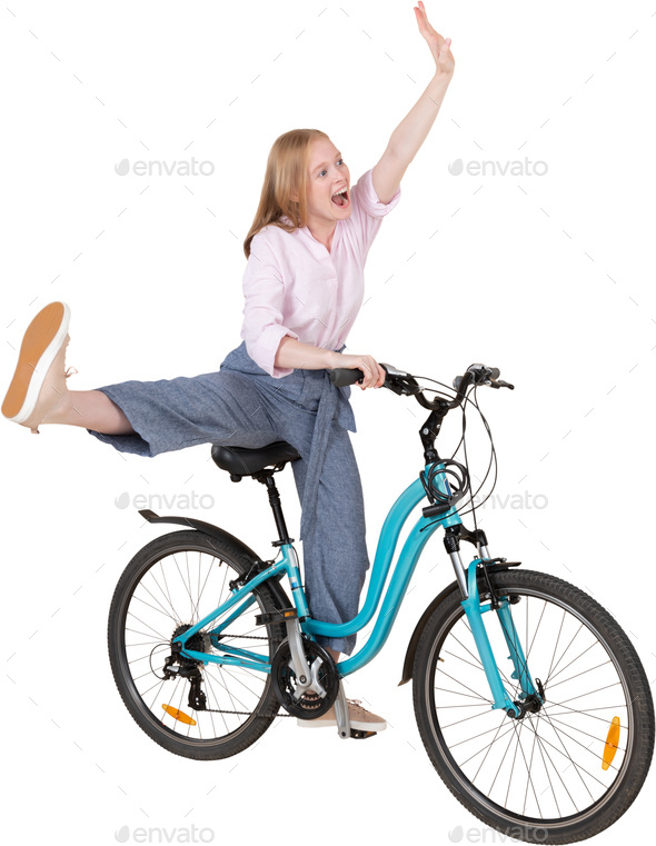 a little girl riding a bike with her leg up in the air