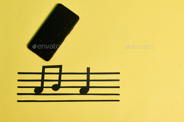 A phone and music notes on a yellow background