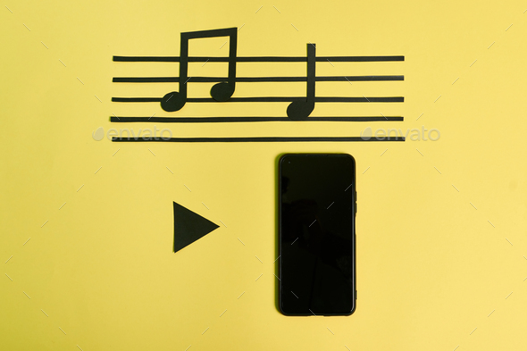 A phone and music notes on a yellow background. Play music