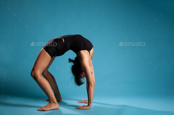 Active athletic woman practicing one leg up yoga pose Stock Photo by  DC_Studio