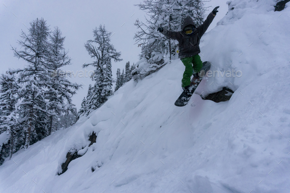 Snowboarder riding extreme and steep mountain terrain - Stock Photo - Images