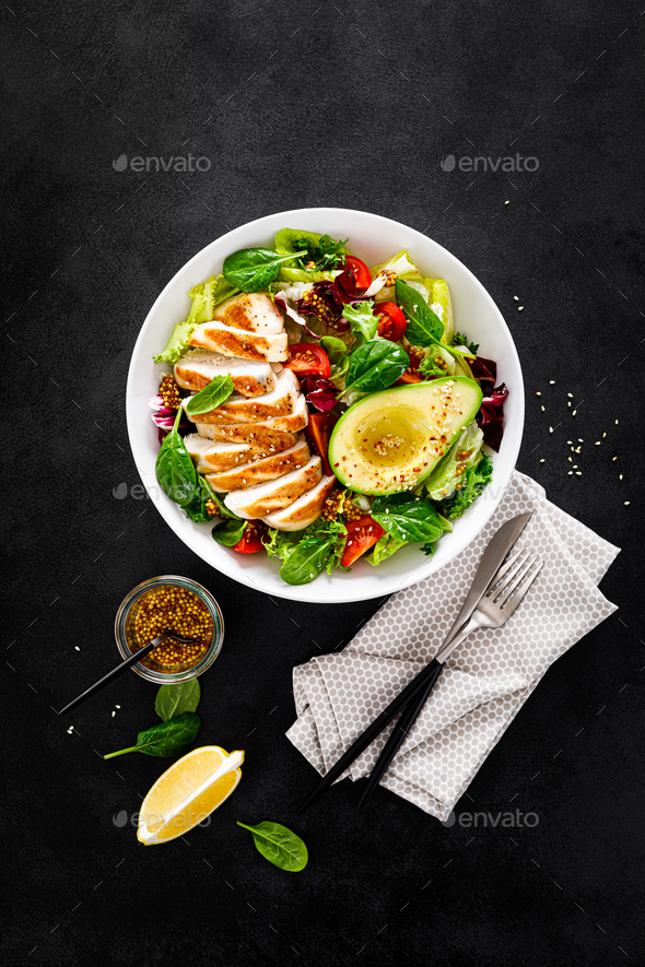 Grilled chicken breast and fresh vegetable salad of tomato, avocado, lettuce and spinach