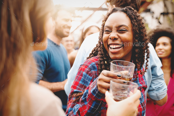 two girls of different races toast together at the college end-of-year party