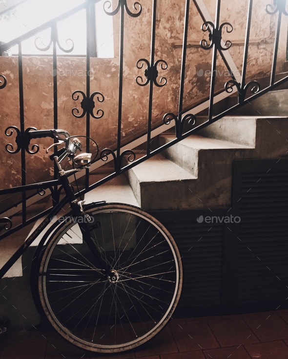 Bicycle parked near stairs indoors. Road bike waits for host. Ancient stairs and modern transport
