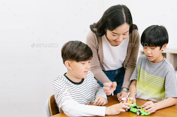 Group of Elementary happy kids and Asian female teacher making electronic toys
