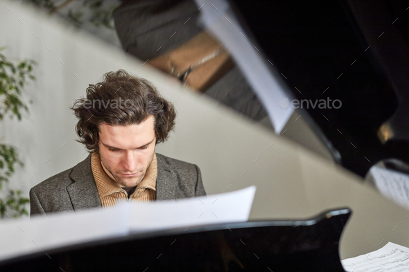Composer composing the new music on piano - Stock Photo - Images
