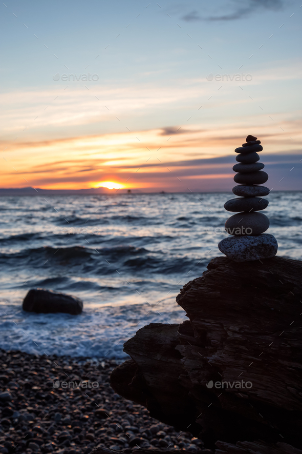 Stack of Rocks piled up by the ocean during a sunny sunset Stock Photo ...