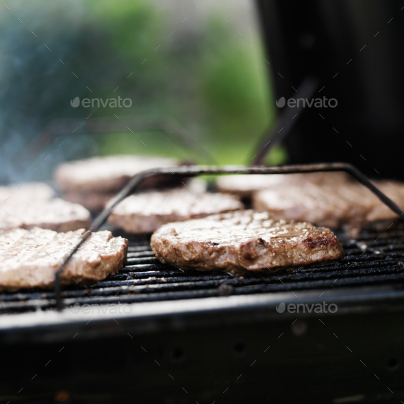 hamburger patties on a charcoal grill Stock Photo by joshua_resnick