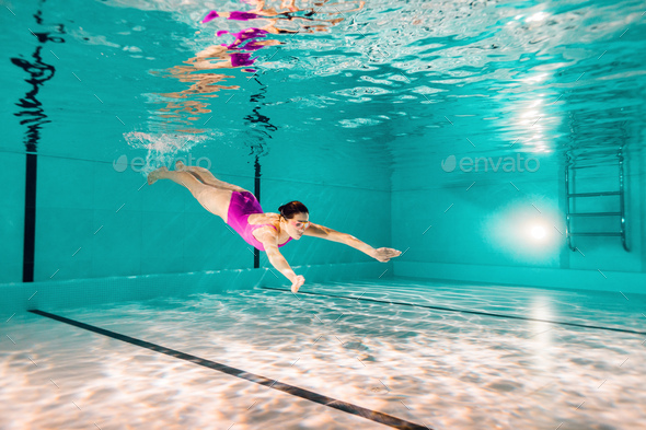 woman swimming in pink swimwear and googles underwater - Stock Photo - Images