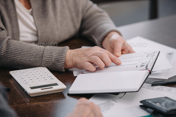 cropped view of senior woman pointing with finger at notebook with ira roth lettering - Stock Photo - Images