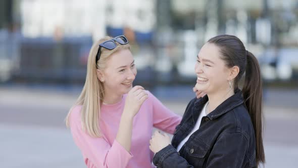 Female friends happily laughing in city