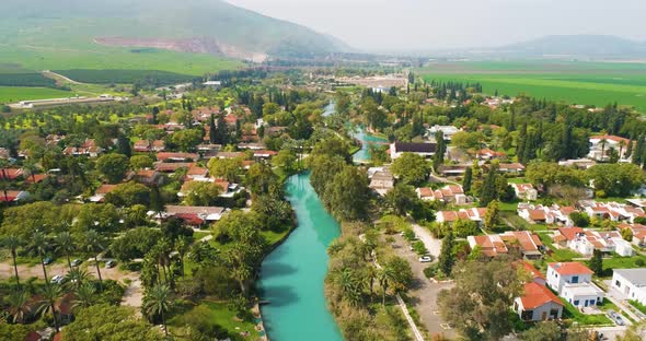 Aerial view of the town with hills in the background and Kibbutzim Stream. alt