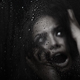 Afraid victim woman at home behind the glass with rain drops - PhotoDune Item for Sale
