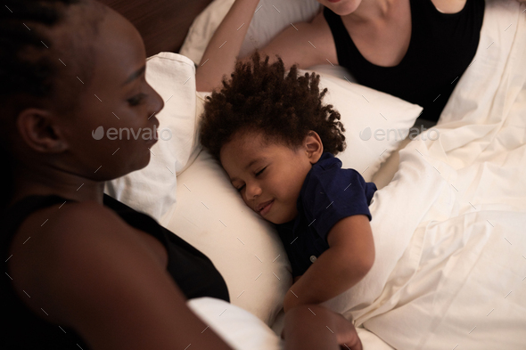 Boy Sleeping in Bed of Parents