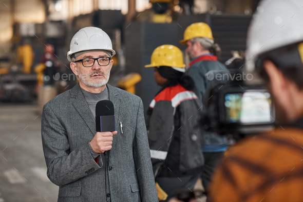 TV journalist shooting the reportage in factory