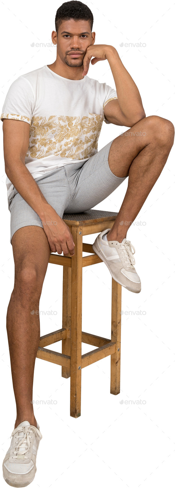 a man sitting on a stool with his foot on a chair