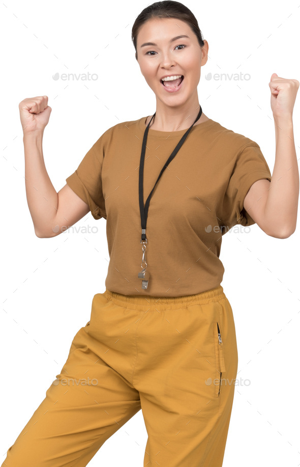 a woman in yellow pants and a brown shirt with her fists in the air