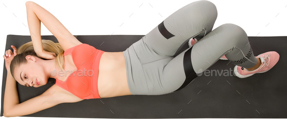 a woman laying down on a gym floor with her legs up in the air