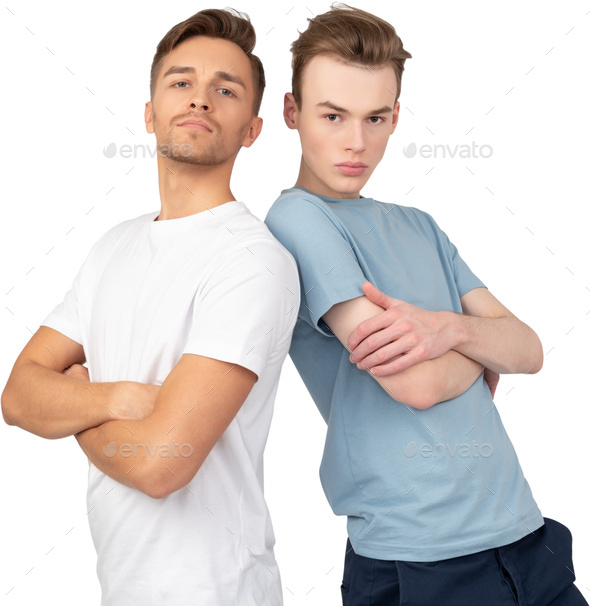 Two Men Standing Next To Each Other With Their Arms Crossed Stock Photo