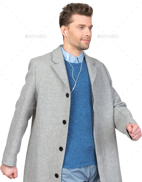 a young man wearing a coat and headphones - Stock Photo - Images