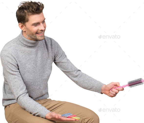 a man is holding a comb in his hand and smiling - Stock Photo - Images
