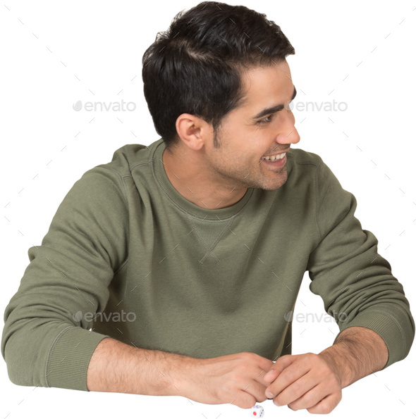 a young man is sitting at a table with his hands - Stock Photo - Images