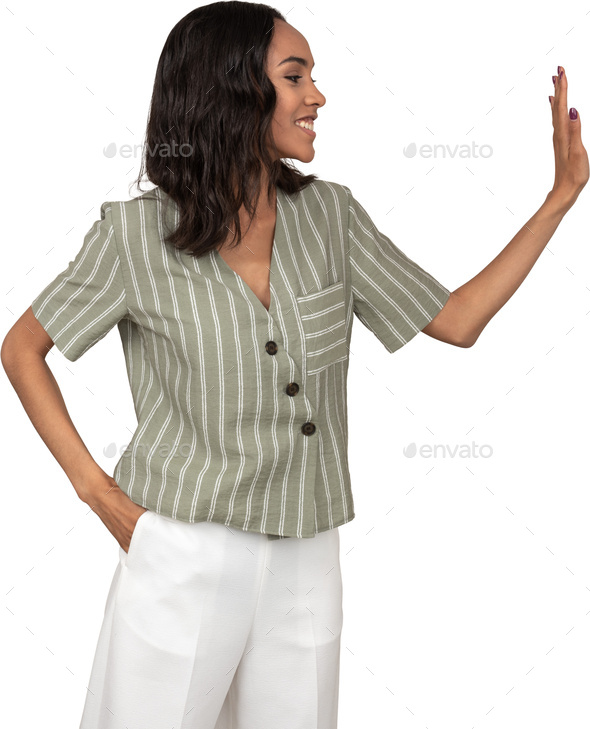 a woman wearing a green striped shirt and white pants with her hands in the air - Stock Photo - Images