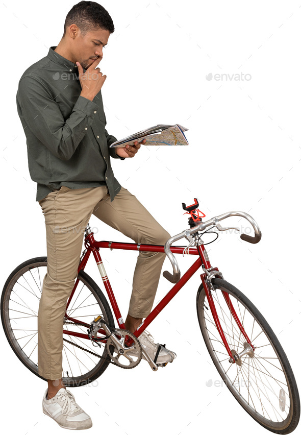 a man sitting on a bike while smoking a cigarette and reading a book