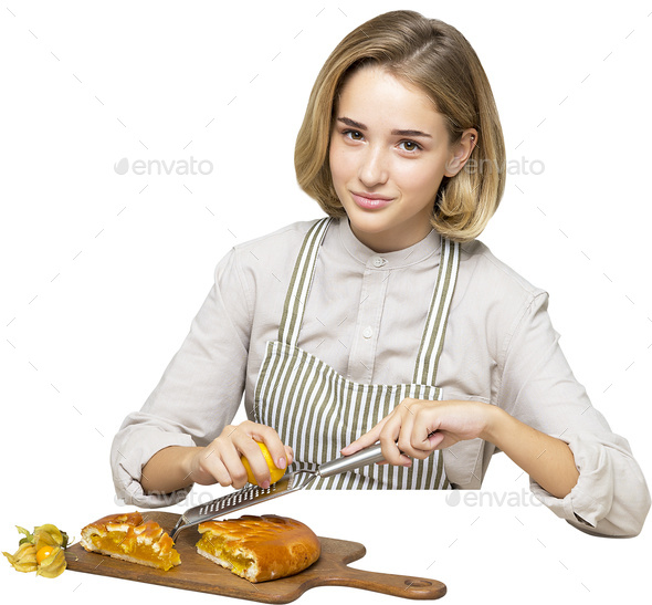 a woman in an apron cutting food with a knife and fork - Stock Photo - Images