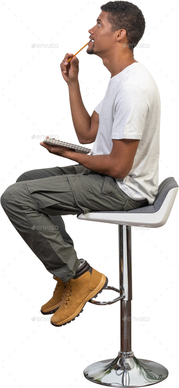 a man sitting on a stool smoking a cigarette - Stock Photo - Images